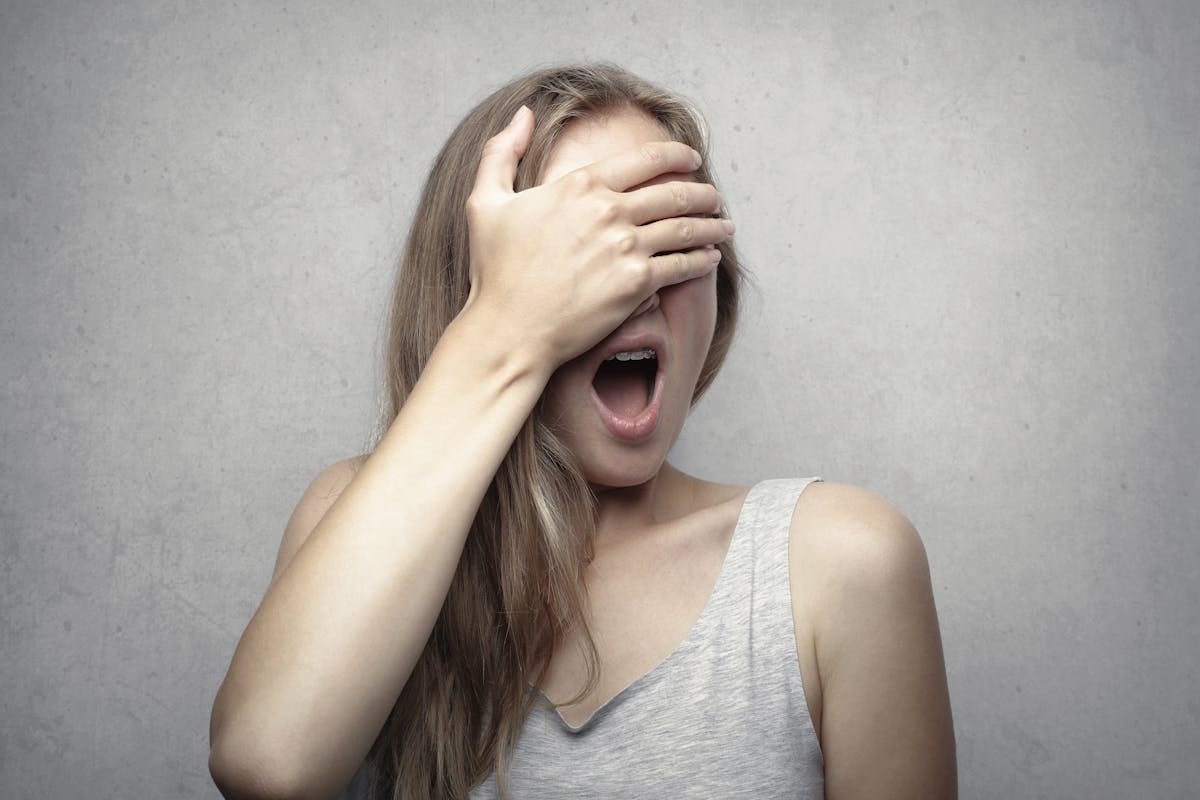 woman vietnamese woman covering face frustration scalp pain too hard pressure — Phụ nữ ôm đầu thể hiện sai lầm khi massage quá mạnh